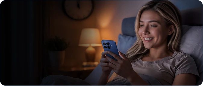 Kobieta korzystająca ze smartfona Xiaomi wieczorem w sypialni