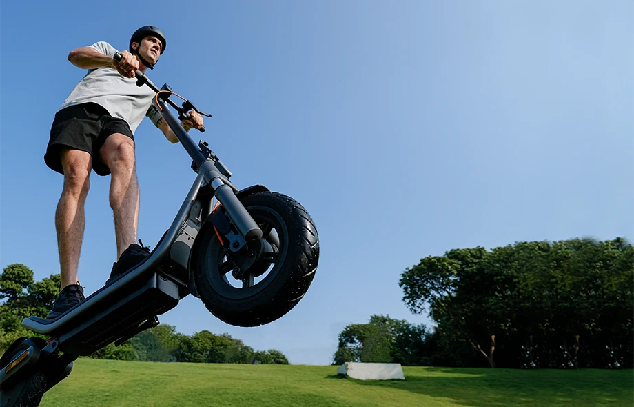 Xiaomi Electric Scooter 6 używana przez mężczyznę jadącego po trawie w terenie rekreacyjnym