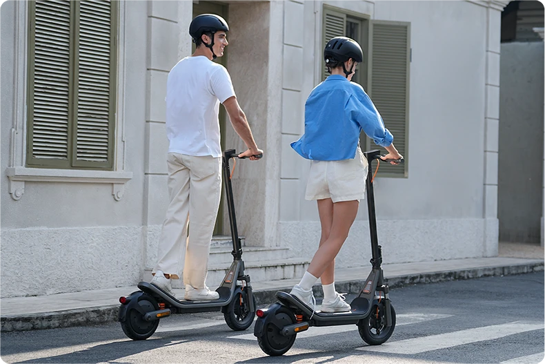 Widok od tyłu na dwie osoby jadące na Xiaomi Electric Scooter 6 po miejskiej ulicy