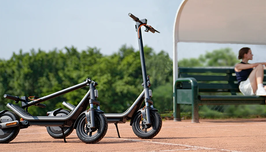 Dwie hulajnogi Xiaomi Electric Scooter 6 zaparkowane obok ławki w przestrzeni rekreacyjnej