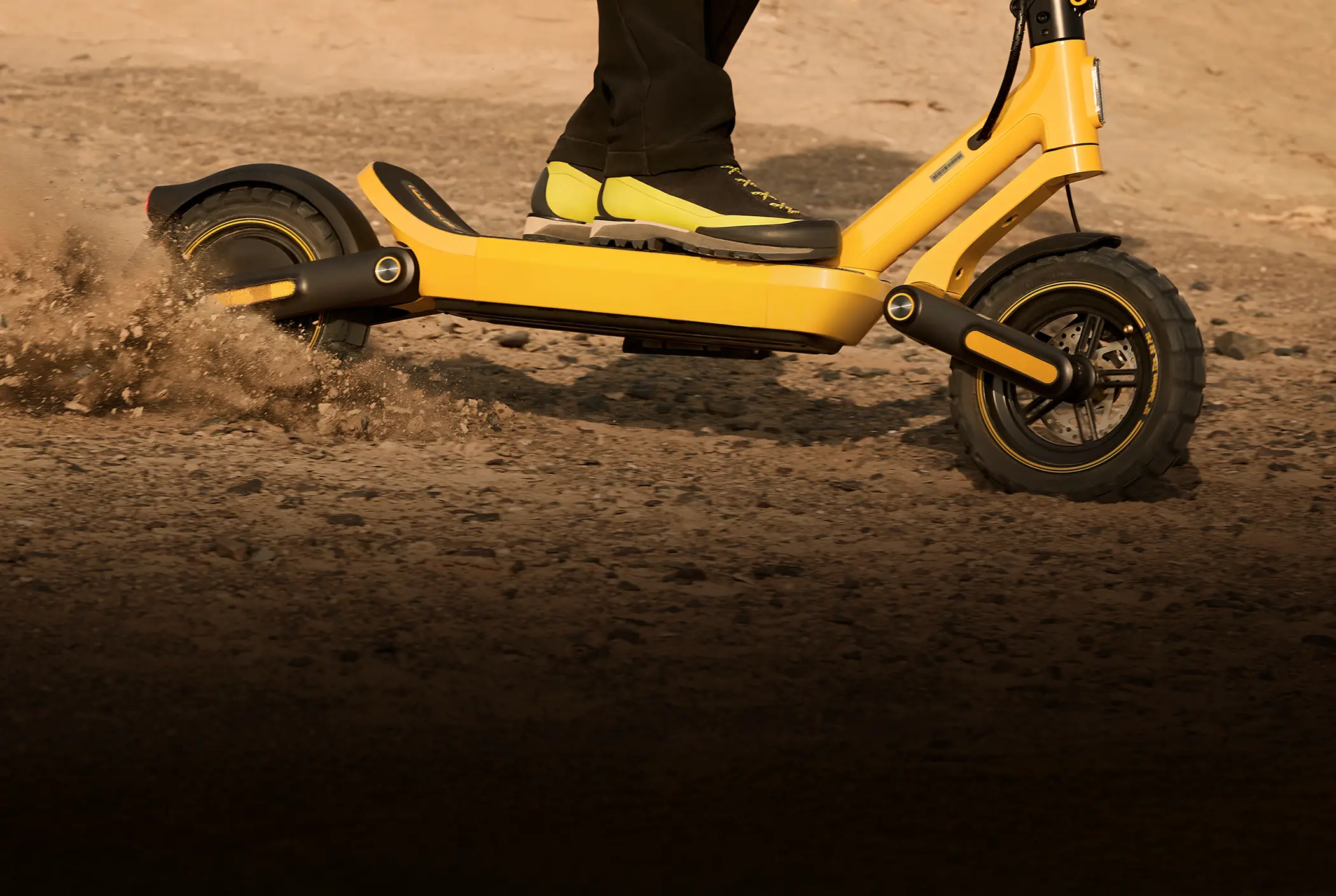 Xiaomi Scooter 6 Ultra podczas jazdy po piaszczystej nawierzchni z widoczną pracą zawieszenia