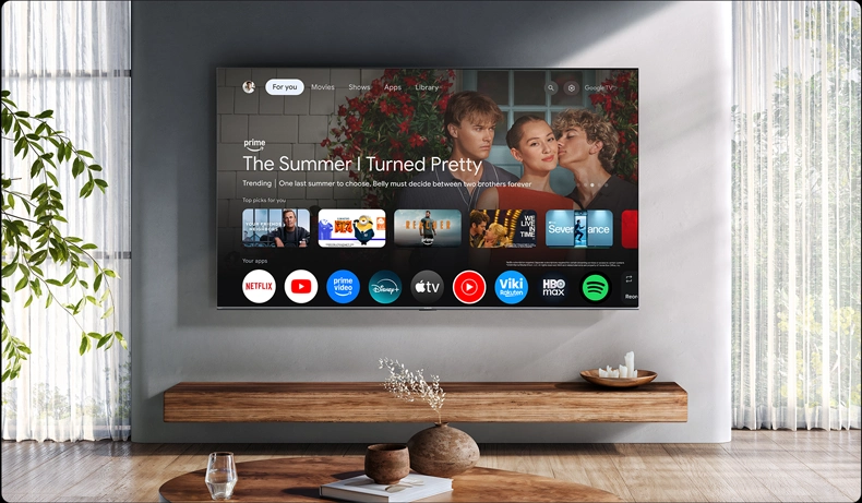 Ekran Google TV z serialem i aplikacjami w nowoczesnym salonie z dużym oknem i minimalistycznym wystrojem.