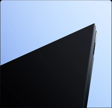 Zbliżenie na górny róg ekranu telewizora Xiaomi z cienką metalową ramką i ekranem pełnoekranowym.
