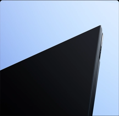 Zbliżenie na górny róg ekranu telewizora Xiaomi z cienką metalową ramką i ekranem pełnoekranowym.